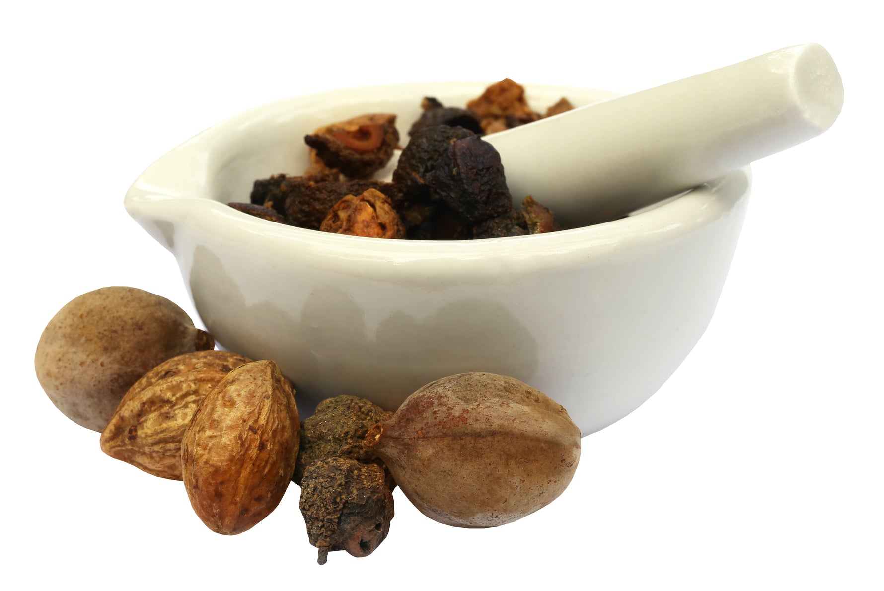 Triphalans tre torkade frukter med haritaki (Terminalia chebula) i mortel, mot vit bakgrund